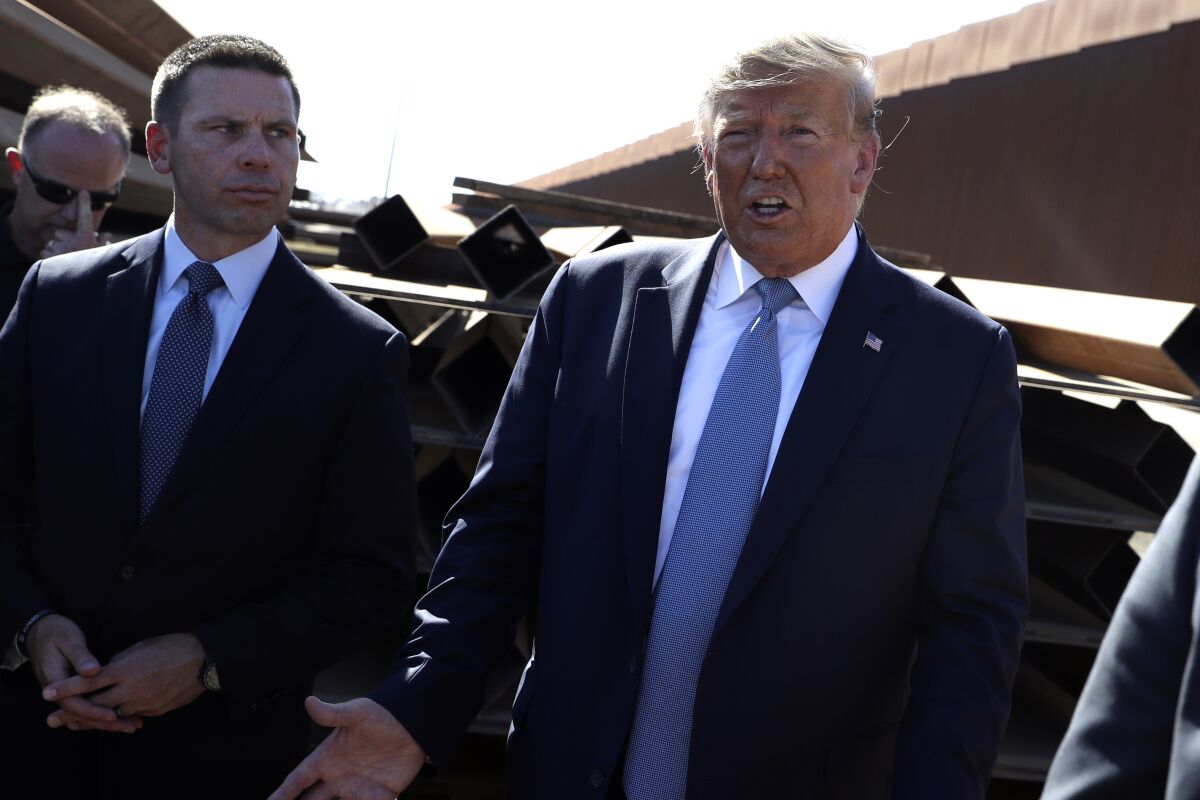 President Trump talks with reporters as he tours a section of the southern border wall with acting Homeland Secretary Kevin McAleenan, left, in Otay Mesa, Calif., on Wednesday.
