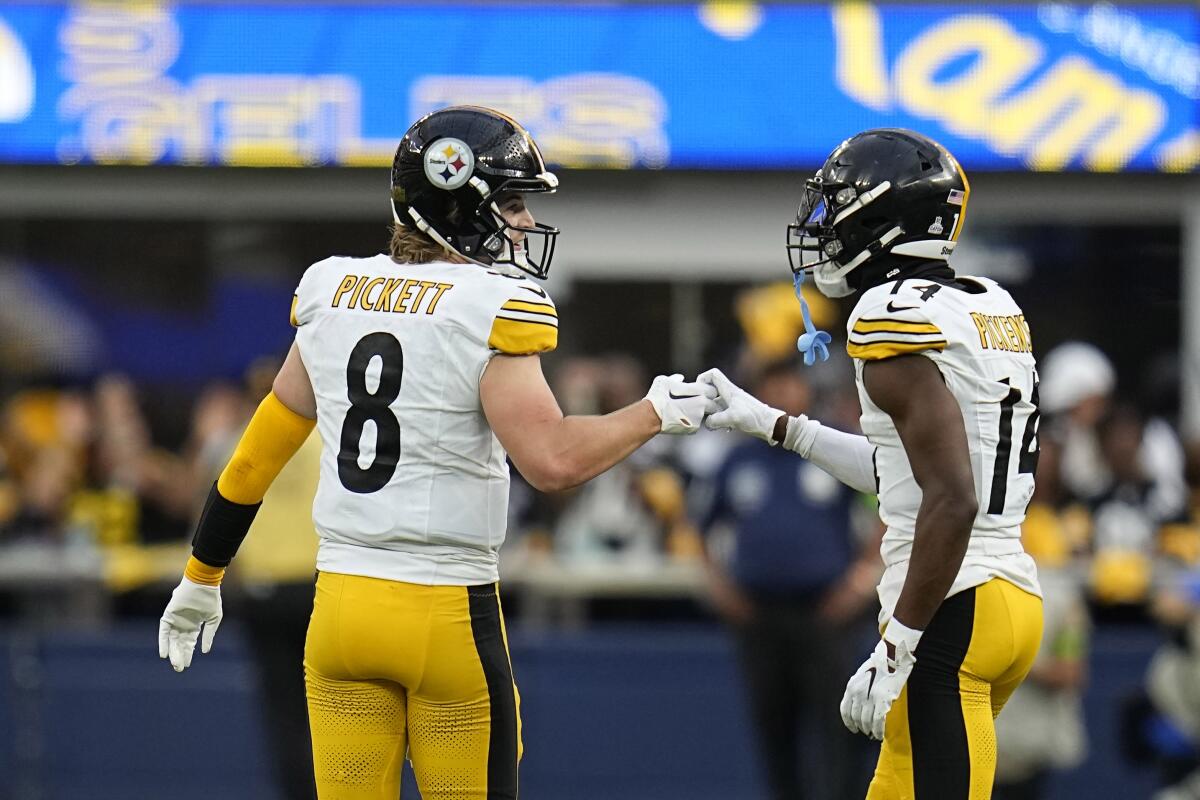 Steelers quarterback Kenny Pickett, left, congratulates  George Pickens after a reception against the Rams.