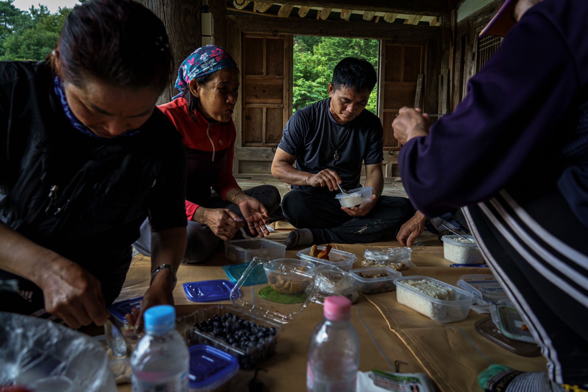 Promdeth Phonsrikaew, center, eats breakfast during a 15-minute break on a tobacco farm.