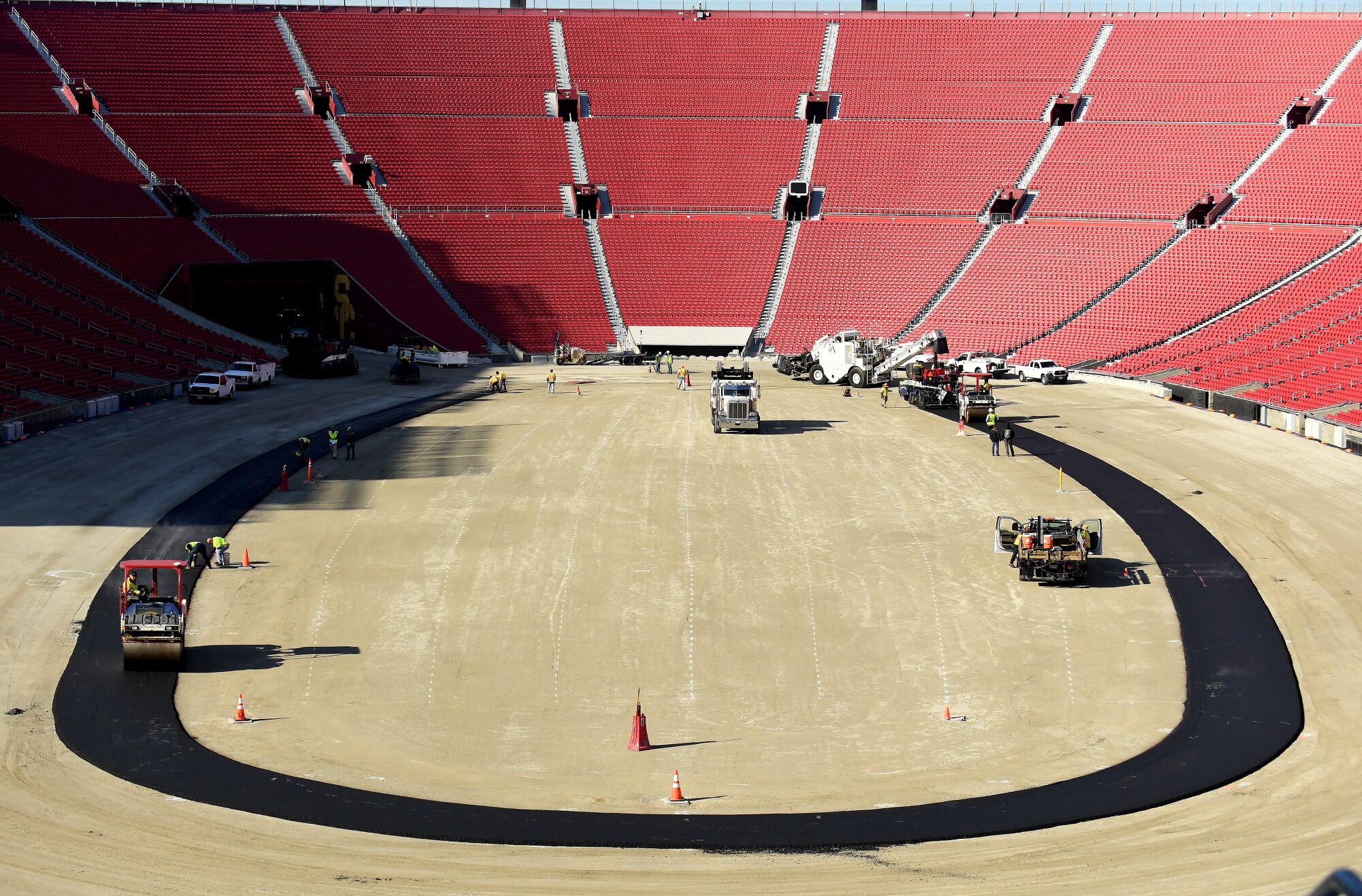 Work crews begin paving the track at the Coliseum in preparation for a NASCAR race.