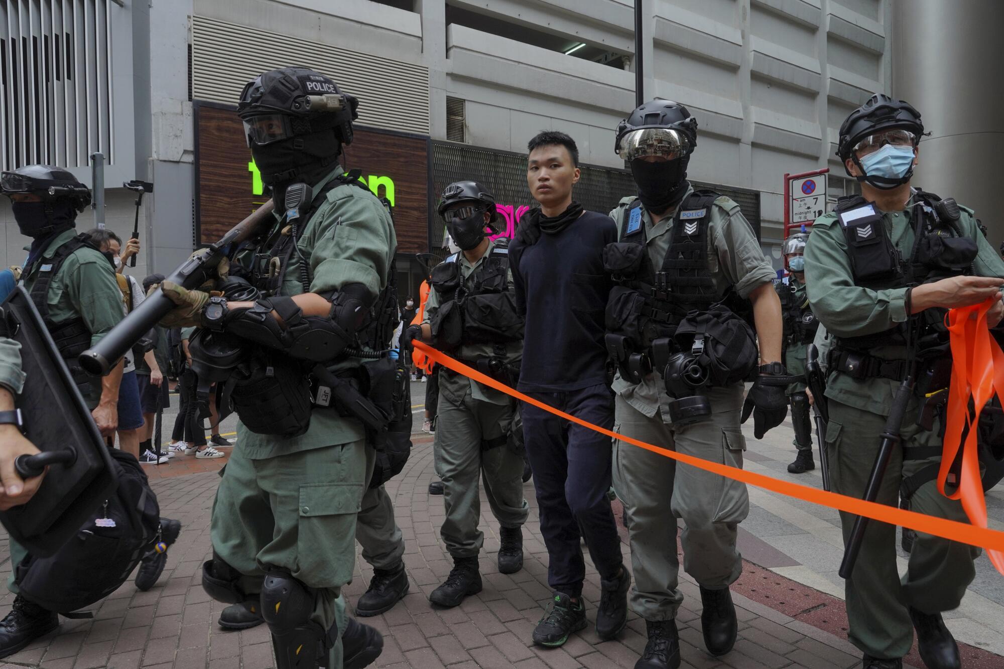 A protester is detained by riot police during the annual handover march in Hong Kong, Wednesday, July. 1, 2020.