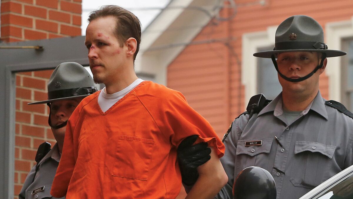 Police escort Eric Frein into the Pike County Courthouse for his arraignment in Milford, Pa., on Oct. 31, 2014.