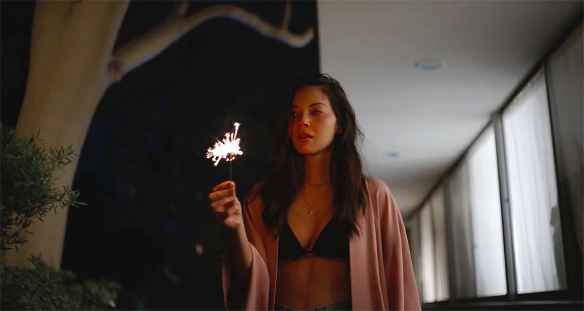 A woman in a bikini holds a sparkler in the movie “Violet.”