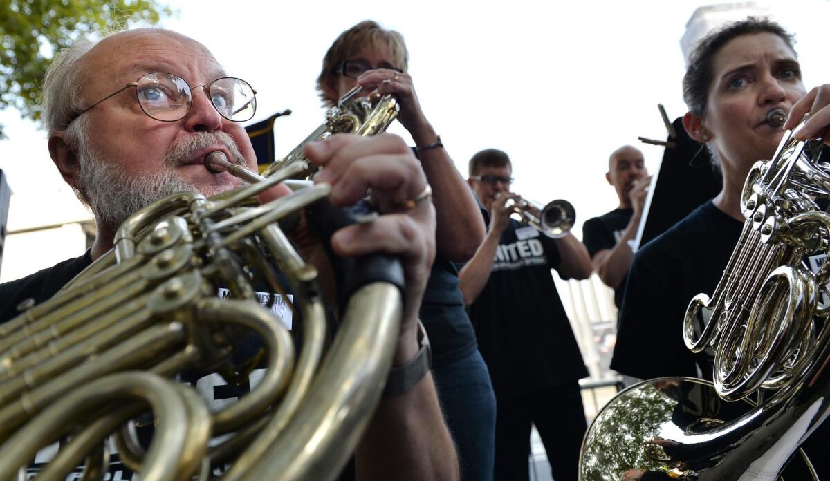 Members of the Metropolitan Opera orchestra played Friday during a labor rally in New York.