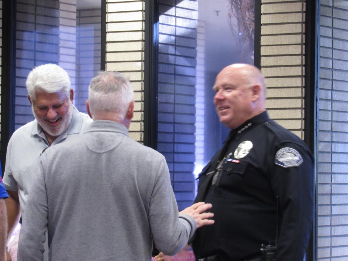 Fountain Valley Police Chief Matthew Sheppard, right, shares a moment with community members before the City Council meeting.