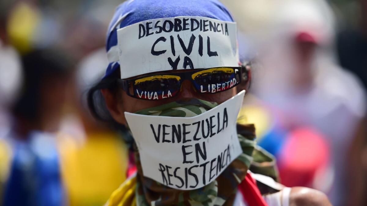 A demonstrator against Venezuelan President Nicolas Maduro's government calls for civil disobedience during a protest in Caracas on Wednesday.