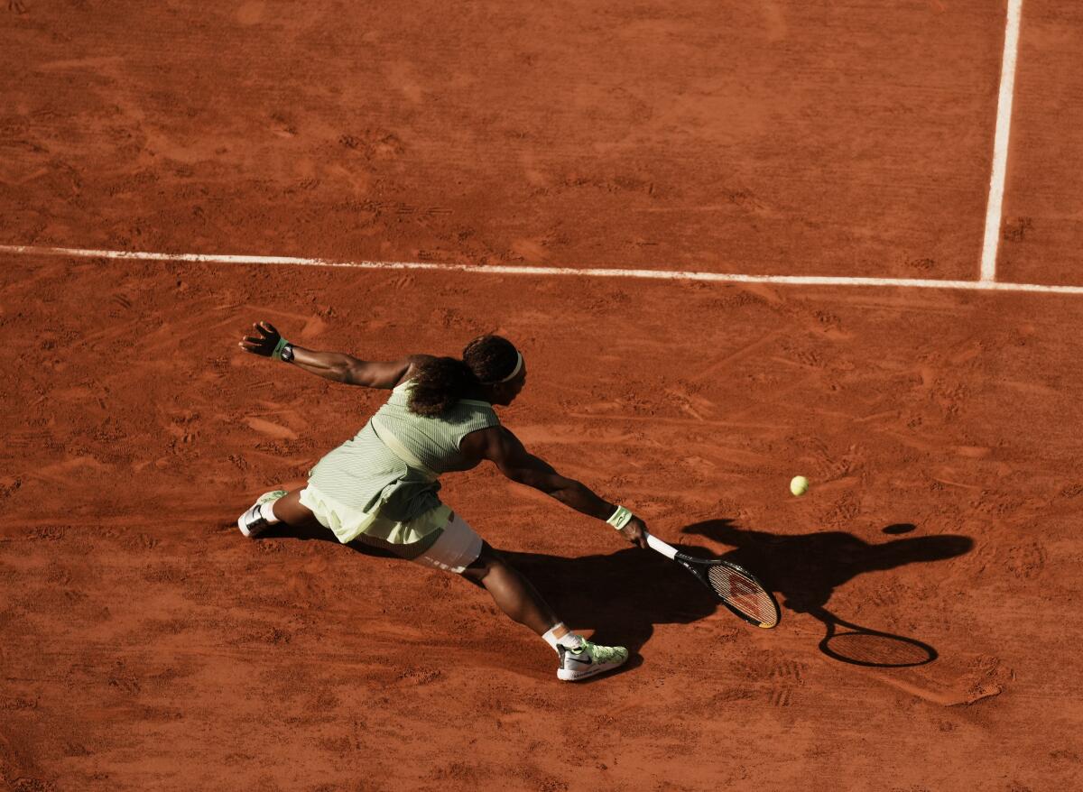Serena Williams reaching for a return on a clay court