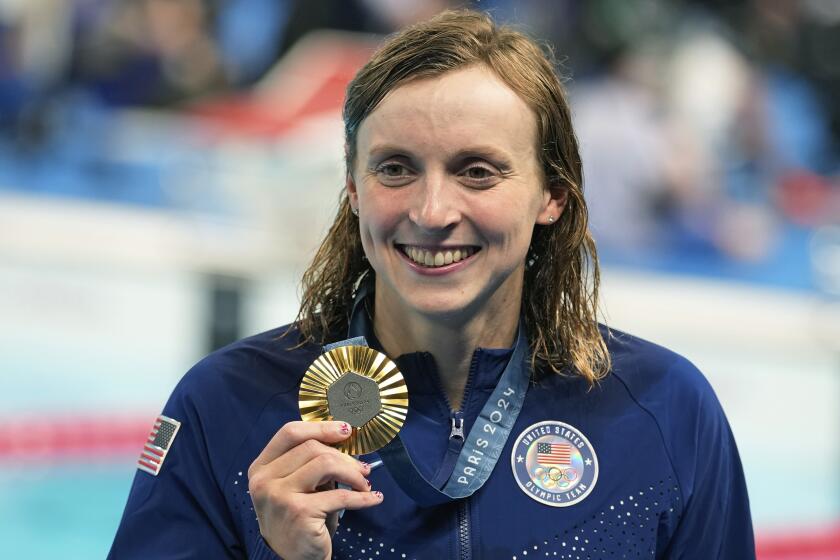 American Katie Ledecky celebrates with the gold medal during the awards ceremony for the women's 800-meter freestyle 
