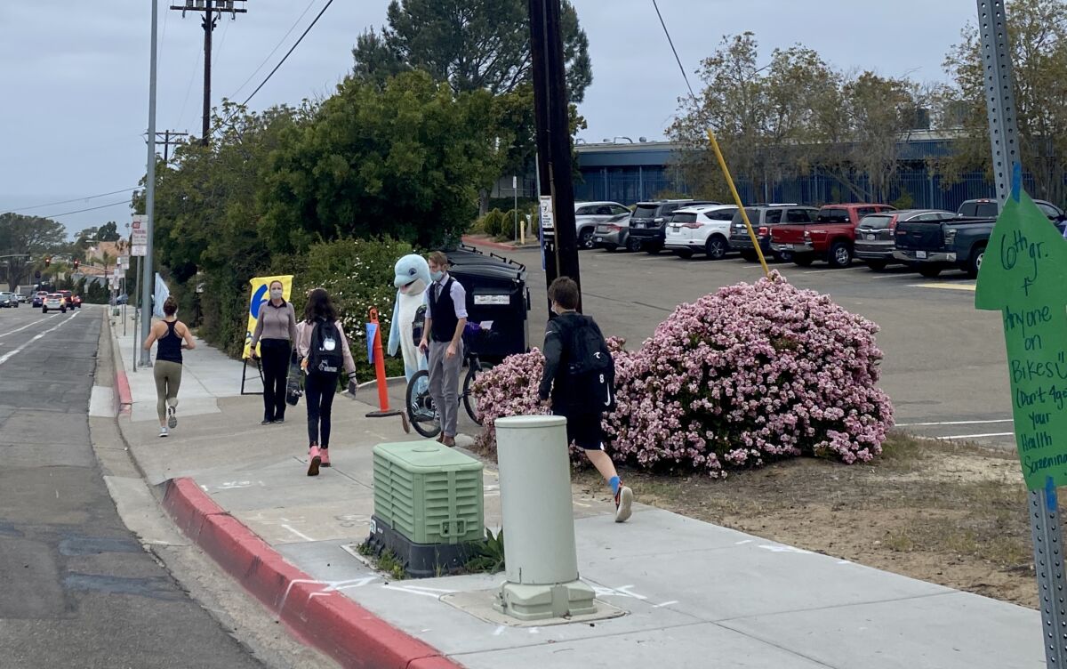 Students head to Muirlands Middle School in La Jolla in April 2021 with a greeting from staff members and the school mascot.
