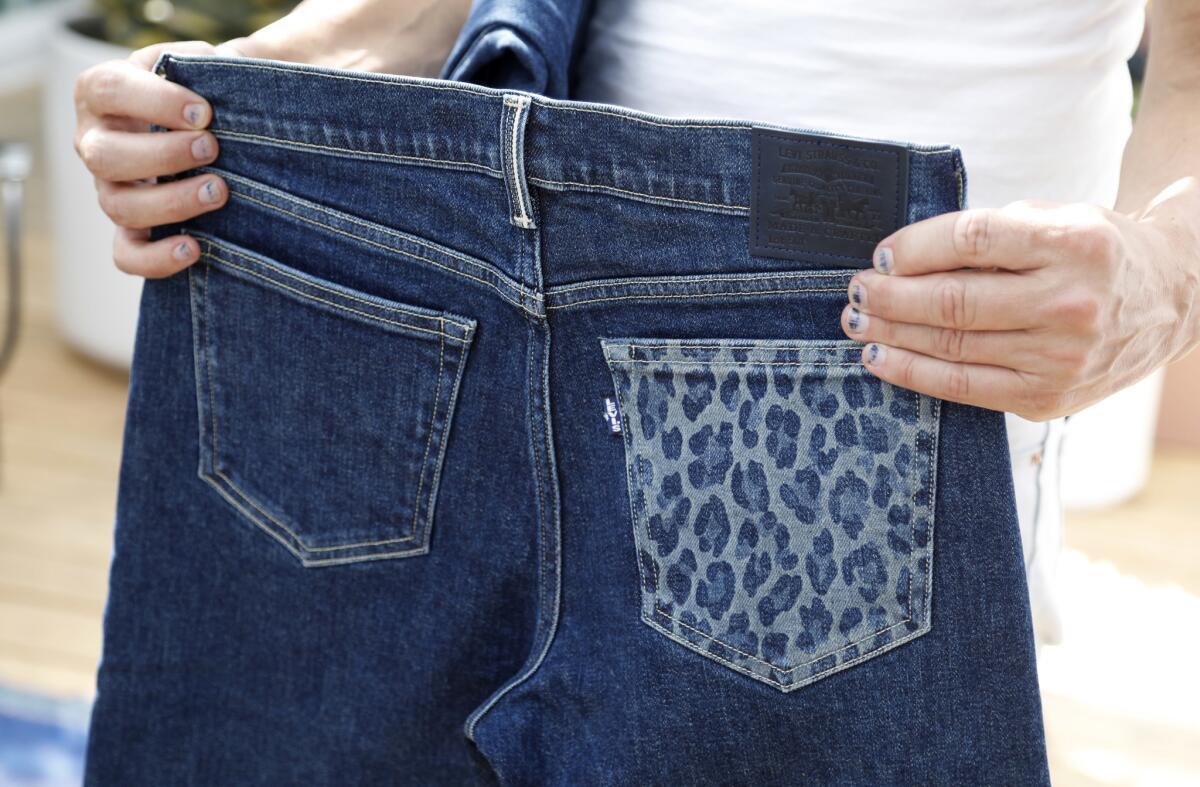 Lily Aldridge ended up customizing two pairs of jeans and drawing cheetah spots on a back pocket with the laser machine. The jeans are displayed by Bart Sights, vice president of technical innovation for Levi's.
