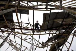 A man works on what is left of Cristo Esperanza Viva church that was affected by forest fires in Vina del Mar, Chile, Tuesday, Feb. 6, 2024. (AP Photo/Esteban Felix)
