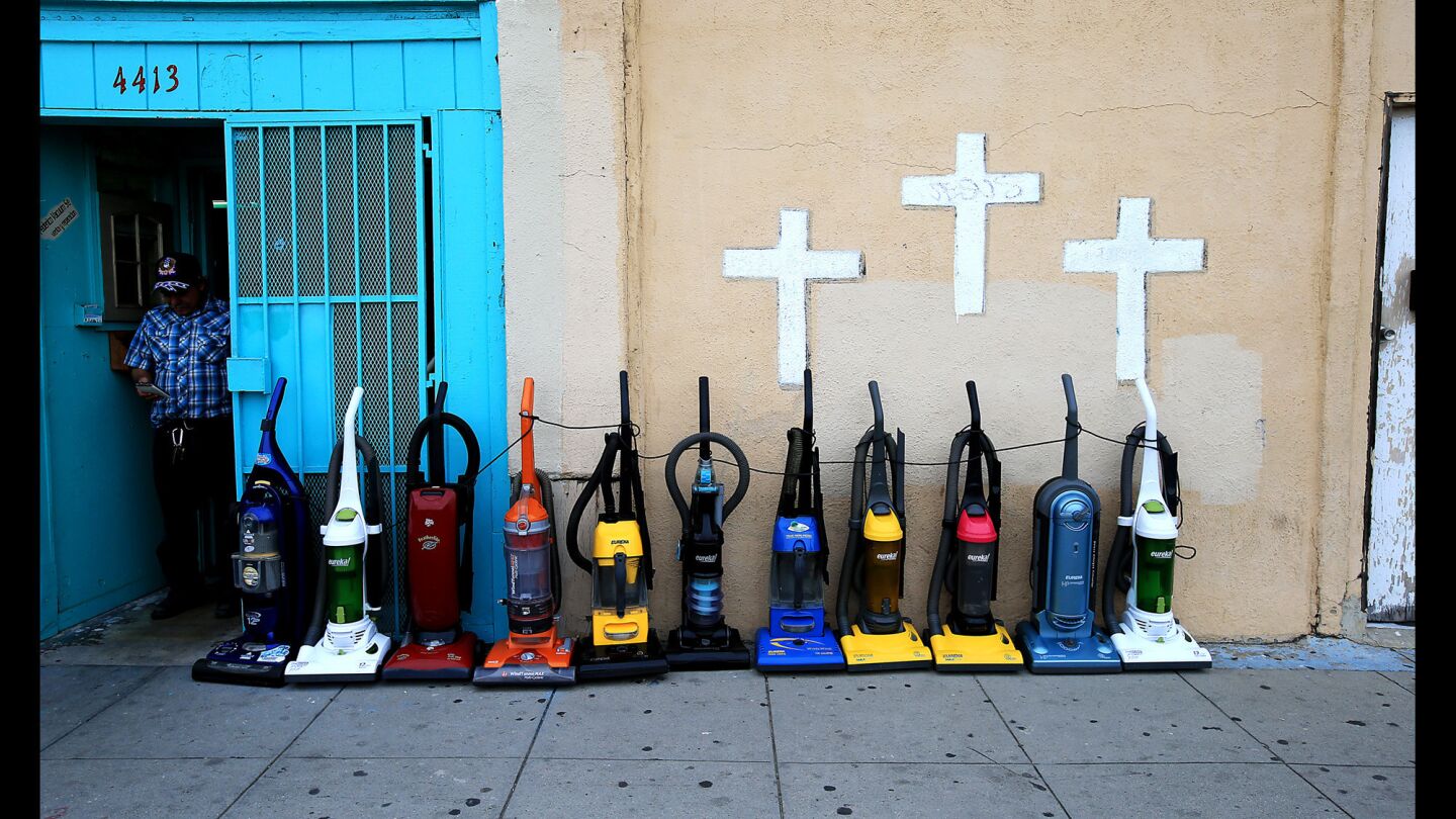 A vacuum repair shop and a storefront church share sidewalk space along Hoover Street.