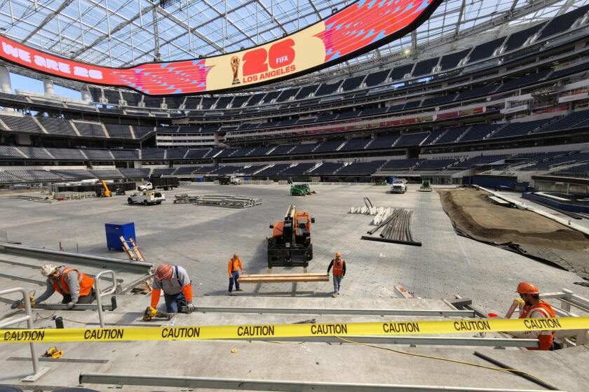 Empleados retiran los asientos de las esquinas de SoFi Stadium en Inglewood este miércoles.