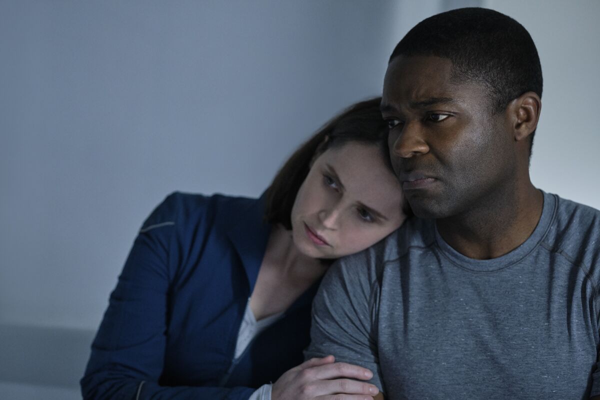 Felicity Jones leans her head on David Oyelowo's shoulder in "The Midnight Sky."