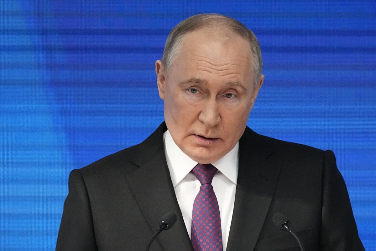 Vladimir Putin speaks before a blue background