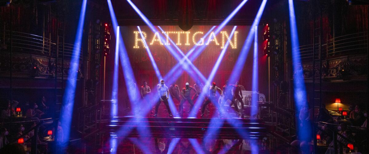 Men dance on a stage with many spotlights in front of them 