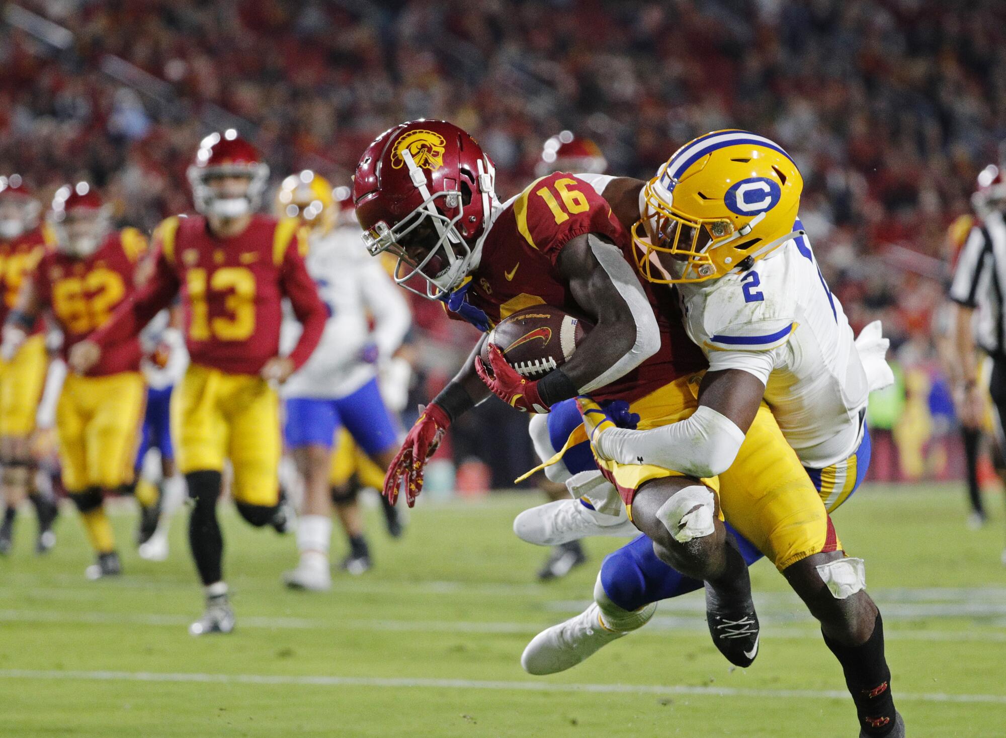 USC wide receiver Tahj Washington is tackled by California safety Craig Woodson.