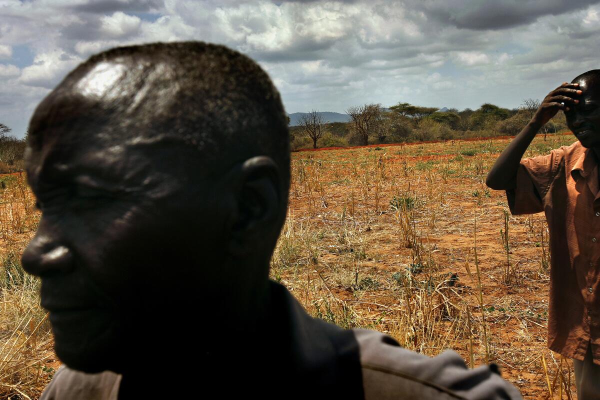 James Mukunga, left, has dealt with years of drought-ruined crops on the small farm he shares with his wife and 12 children in eastern Kenya, about 200 miles from the refugee camps. The family chopped down their few remaining trees to make charcoal to sell.