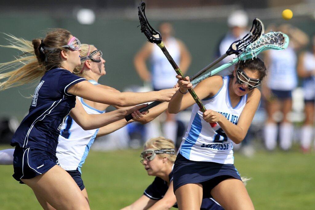 Corona del Mar High's Sabrina Smith, right, is smacked in the head by teammate Payton Carter, second from left, and Newport Harbor's Maxine Aiello, far left, as they compete for a loose ball during the Battle of the Bay game on Friday.