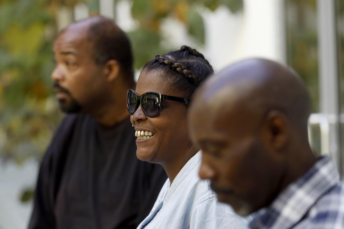 (From L-R), Duanne Hardaway, Big Mama and Keith Gaston sits in the court yard following the grand opening celebration at their new apartment on October 26, 2019.