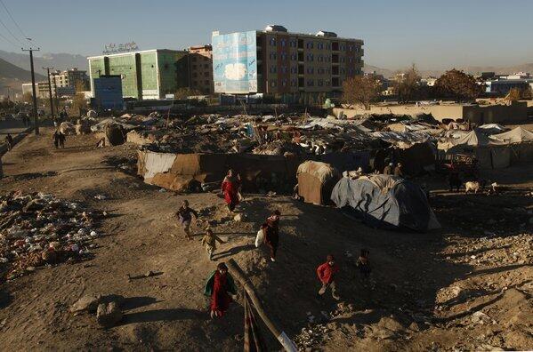 Young Afghans run near one of the makeshift camps for the displaced around Kabul, where more than 30,000 people have settled in illegal camps in search of jobs and shelter, according to the Office of the United Nations High Commissioner for Refugees
