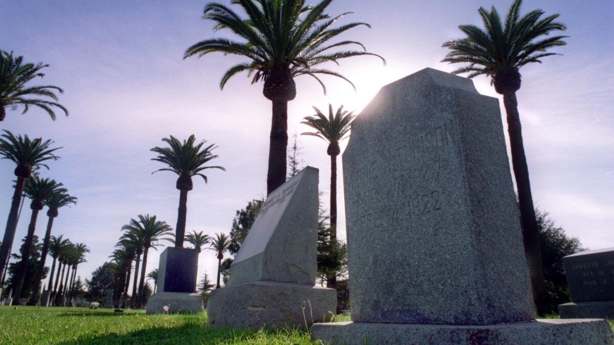 Palm trees provide a backdrop for a row of headstones at Santa Ana Cemetery.