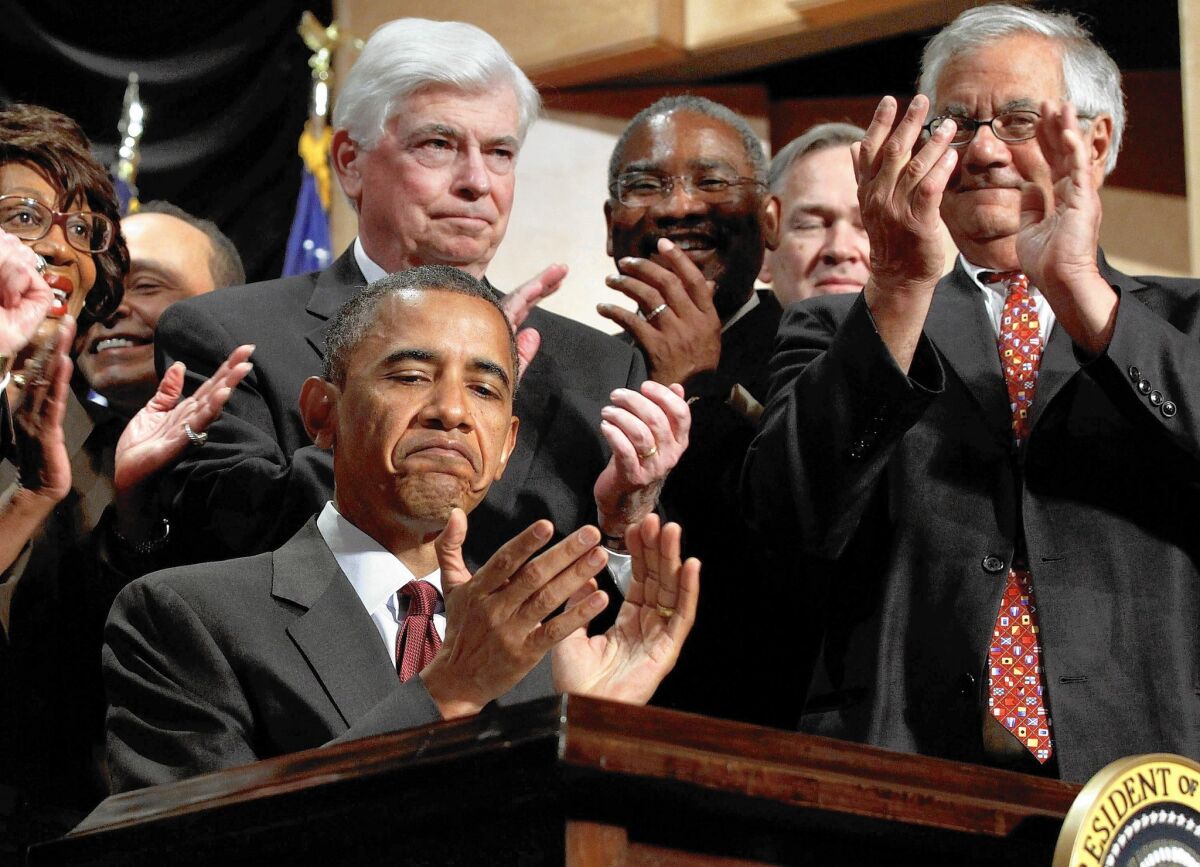 President Obama applauds after signing the Dodd-Frank bill into law during a ceremony with former Sen. Christopher Dodd, center, former Rep. Barney Frank, right, and other members of Congress on July 21, 2010.