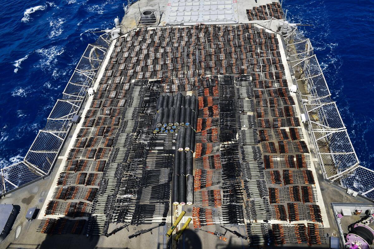 Thousands of weapons laid out in rows on a ship deck