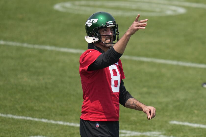 New York Jets quarterback Aaron Rodgers throws grass in the air at the NFL football team's training facility in Florham Park, N.J., Tuesday, June 6, 2023. (AP Photo/Seth Wenig)