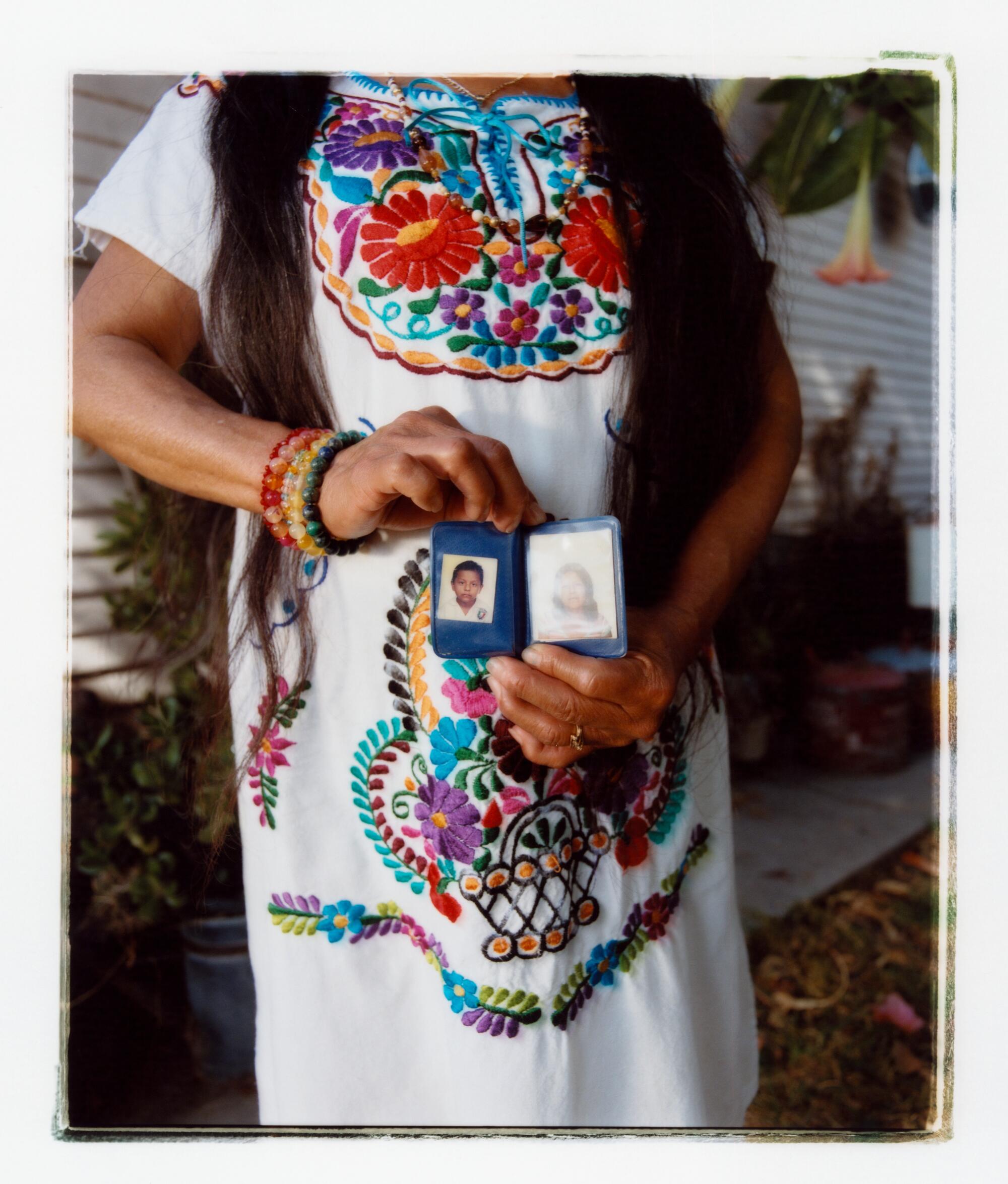 Holding photos at her waist.