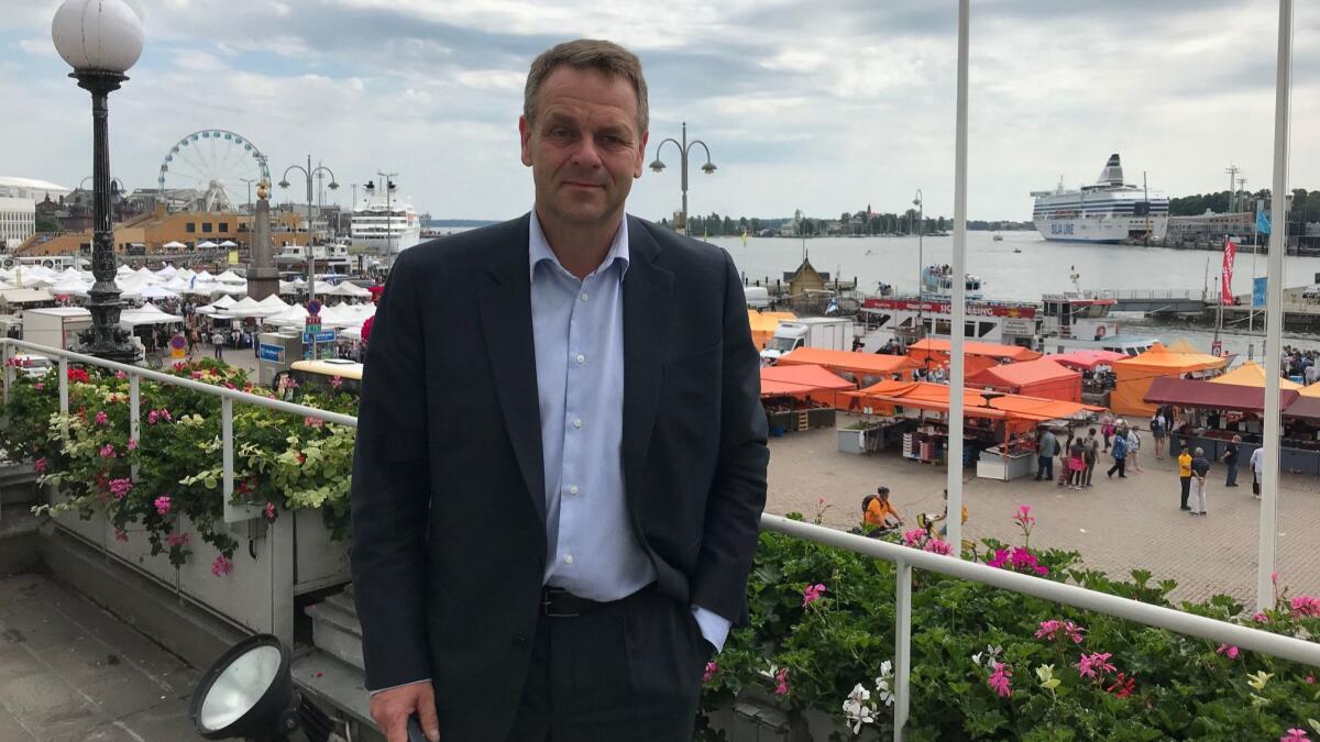Helsinki Mayor Jan Vapaavuori stands on a balcony of City Hall overlooking the Finnish capital's market square and waterfront.