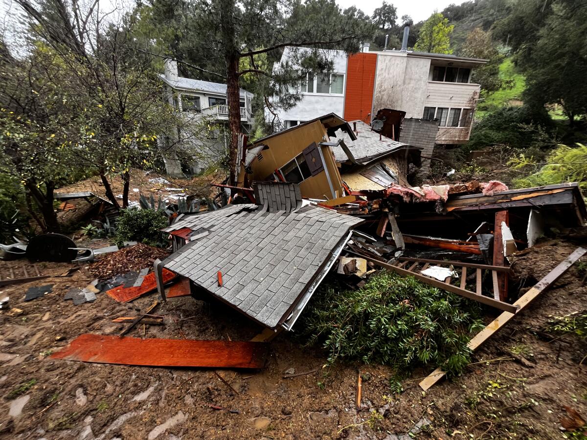 Roof shingles and wood beams lay in tatters from a home destroyed by a mudslide.