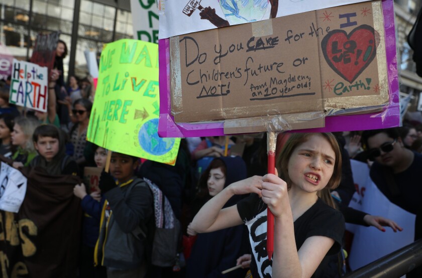 Students carry signs as they march during the Youth Climate Strike on March 15, 2019, in San Francisco.