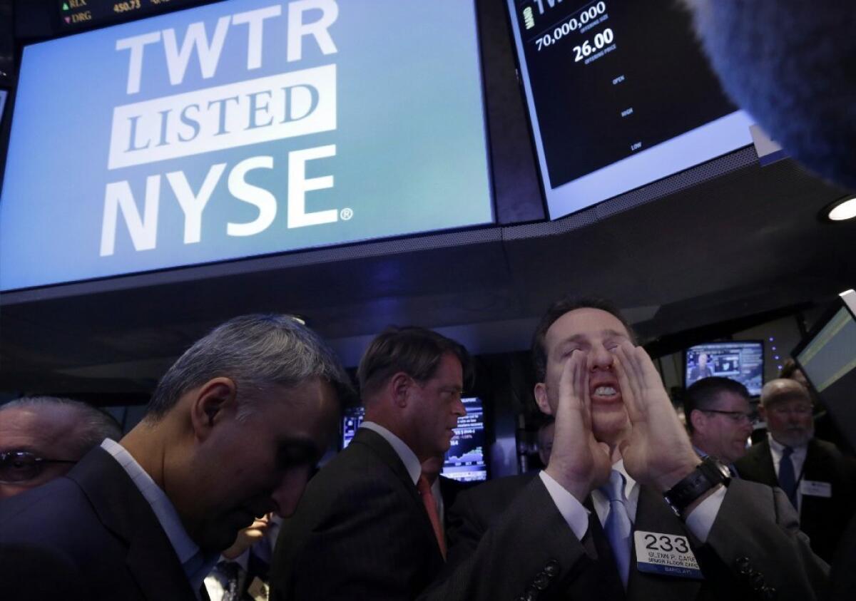 Specialist Glenn Carell calls out prices on the floor of the New York Stock Exchange before Twitter stock begins trading during its initial public offering.