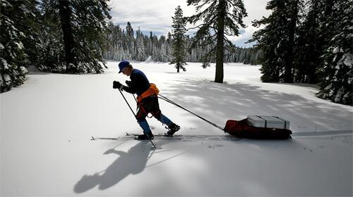 Frank Gehrke of the state Department of Water Resources pulls gear to Gin Flat in the Sierra. The site is an ideal spot to test the premise that a warming climate will bring more flooding and less snowpack to fill reservoirs in mid-summer.