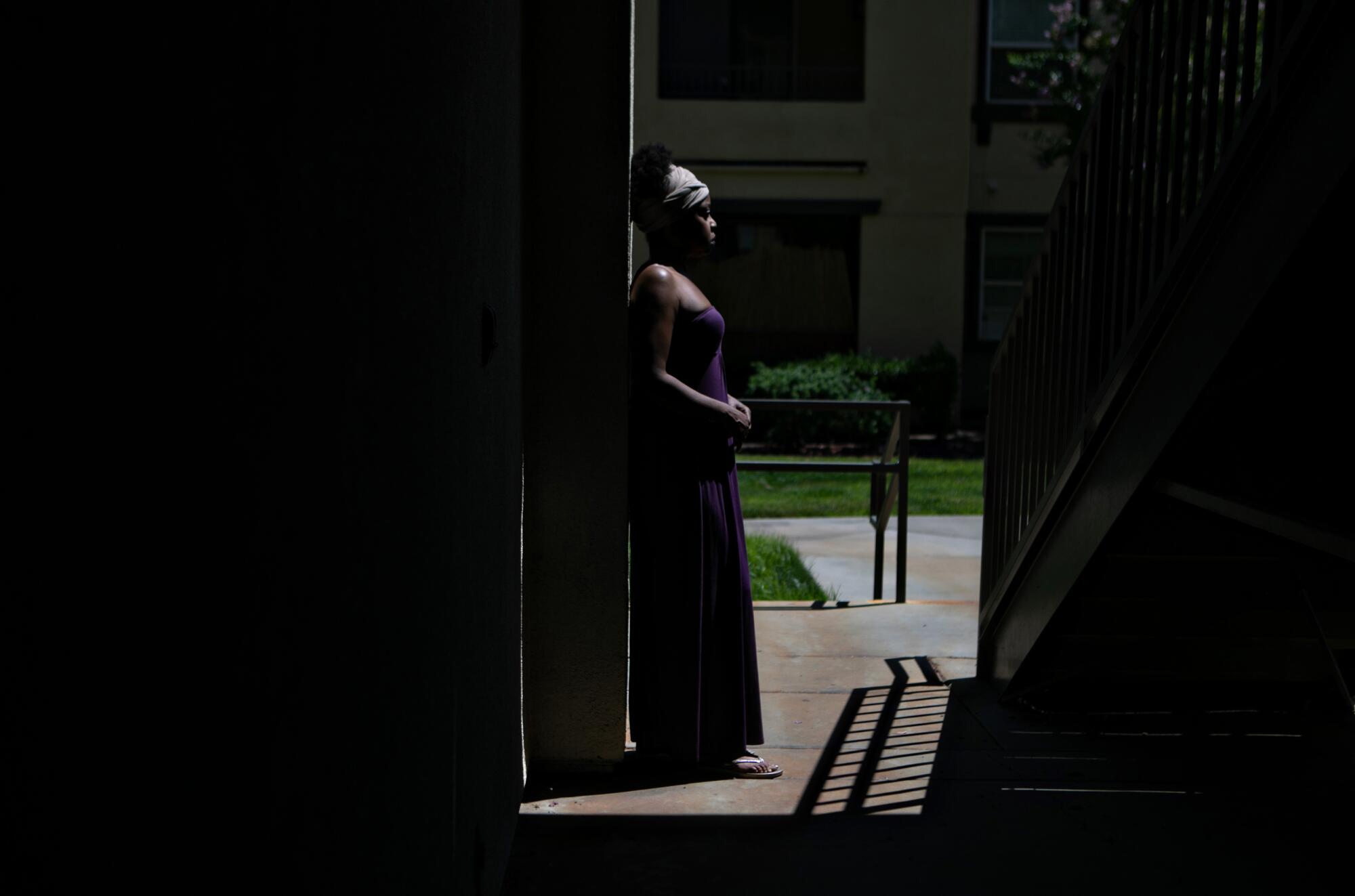 A woman standing in a walkway at an apartment