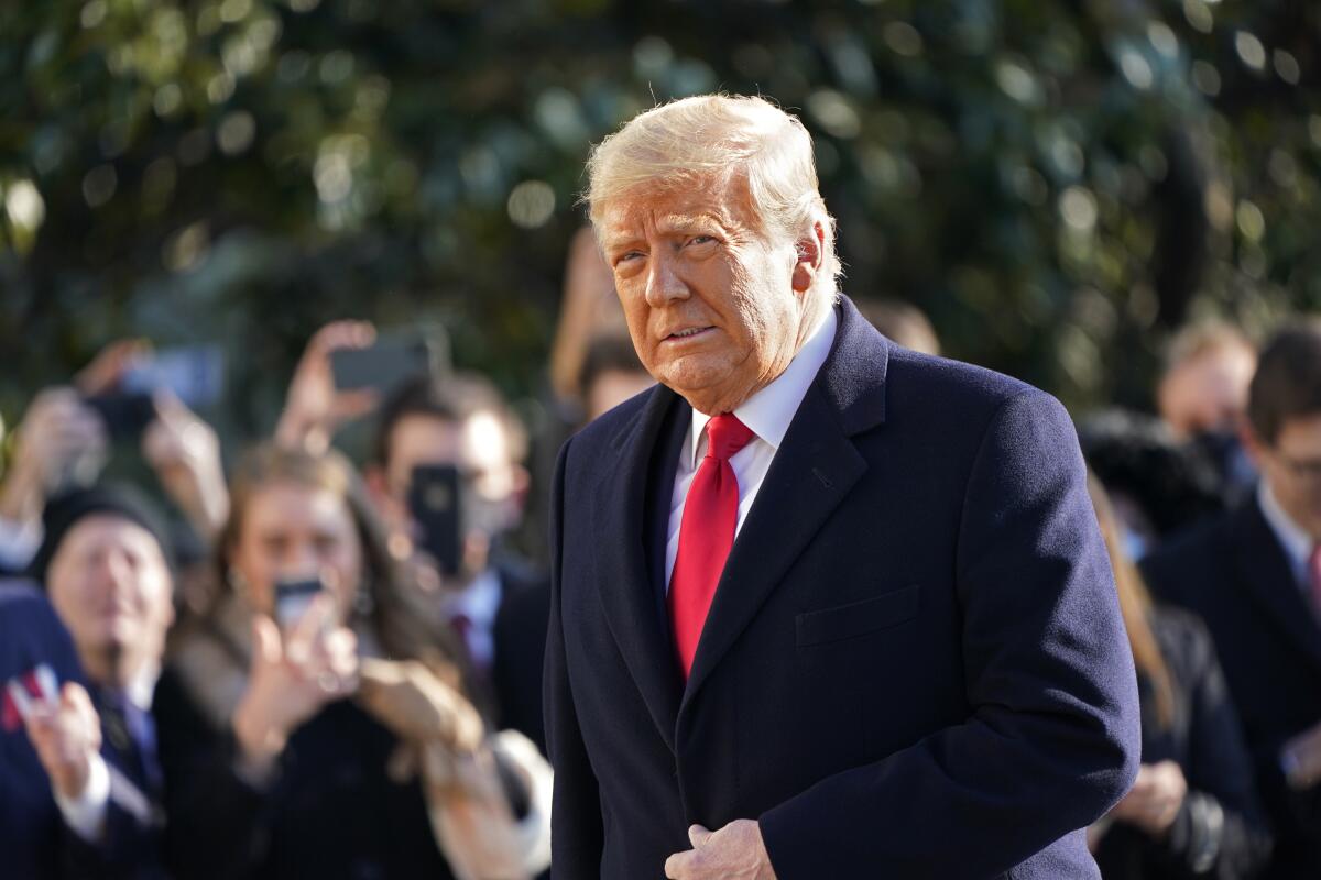 President Trump walks to board Marine One at the White House on Tuesday as a crowd of supporters looks on.