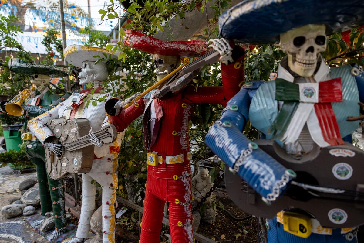A colorful skeleton mariachi band made of recycled tin cans outdoors at a restaurant.