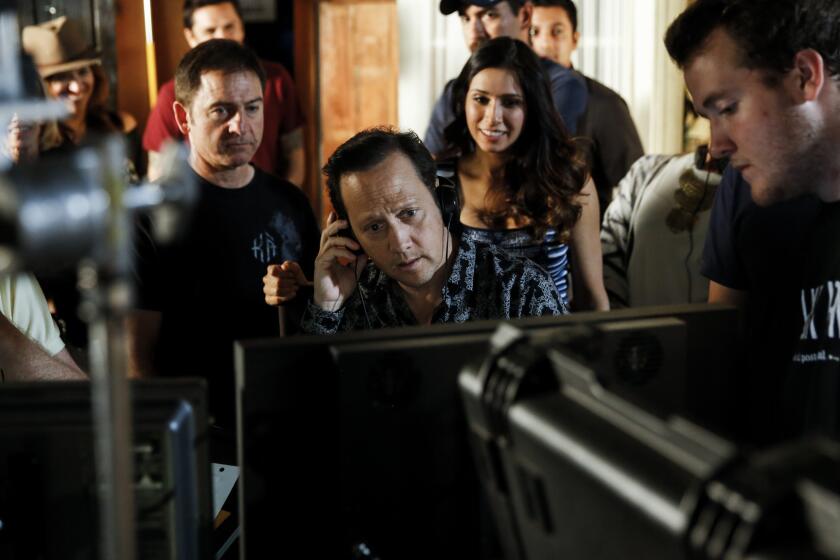 Rob Schneider, center, watches a playback of a scene he acted in and directed for his self-financed sitcom "Real Rob" at Los Angeles Film School in Hollywood.