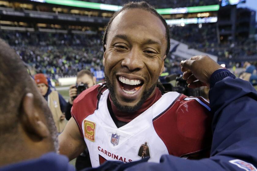 Arizona Cardinals' Larry Fitzgerald greets a Seattle Seahawks staff member after an NFL football game, Sunday, Dec. 30, 2018, in Seattle. (AP Photo/John Froschauer)