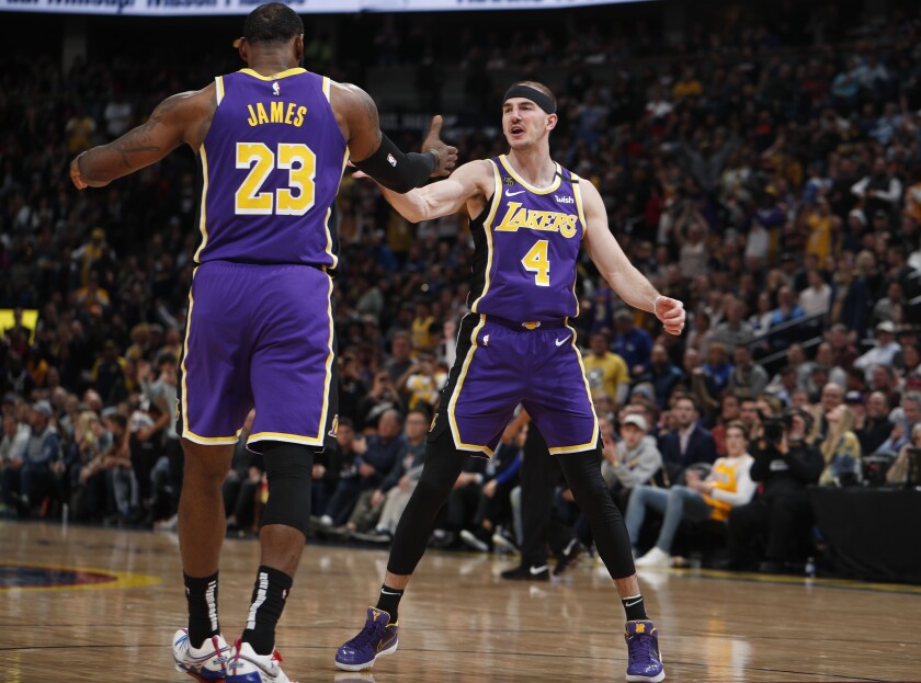 Lakers forward LeBron James congratulates guard Alex Caruso (4) after he scored late in the second half against the Nuggets in a game Feb. 12, 2020, in Denver.