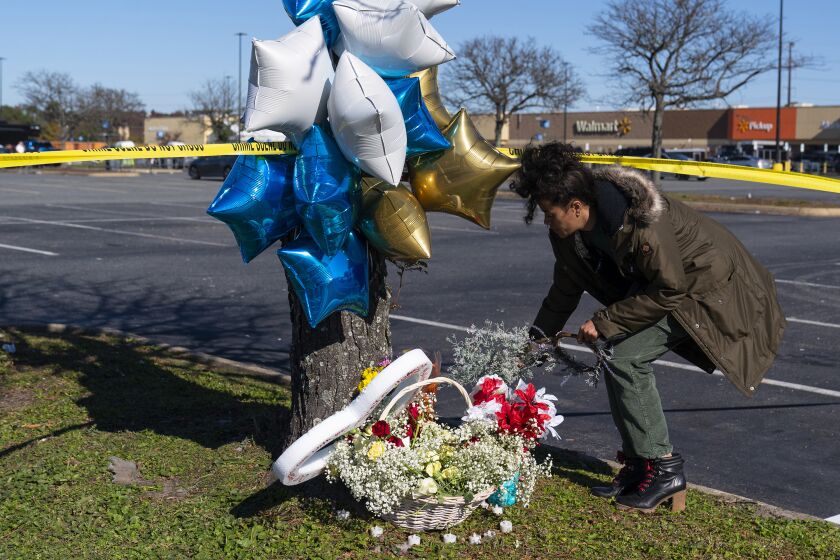 Shyleana Sausedo-Day, de Portsmouth, Virginia, coloca flores el miércoles 23 de noviembre de 2022 cerca del lugar donde la noche anterior fue perpetrada una masacre a tiros en un Walmart, en Chesepeake, Virginia. (AP Foto/Alex Brandon)