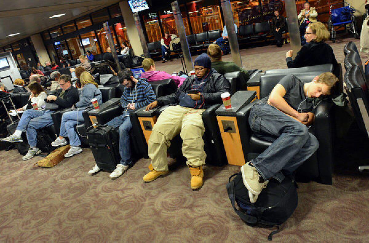 Travelers wait for a flight at Phoenix Sky Harbor Airport in Phoenix last year. Despite a drop in on-time performance by the nation's airlines, complaints dropped by 14% in 2013, compared to the previous year.