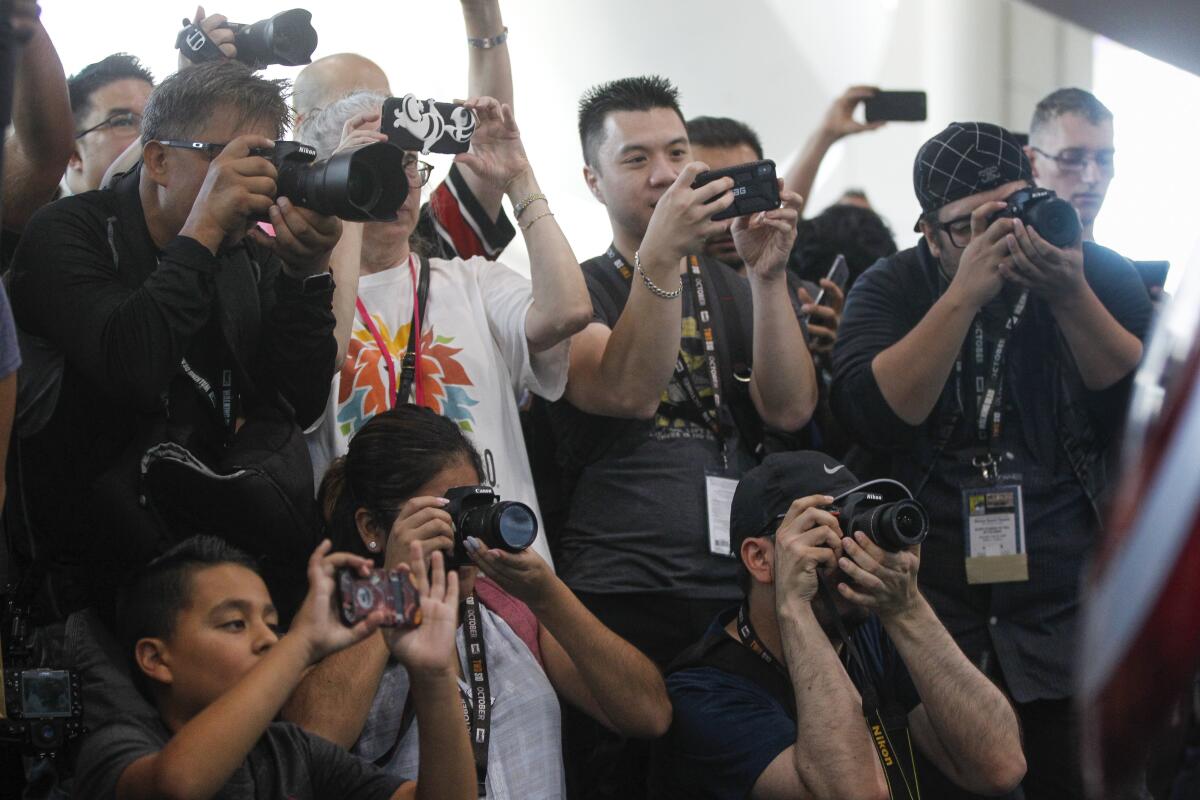 People take pictures of cosplayers at the Comic-Con 