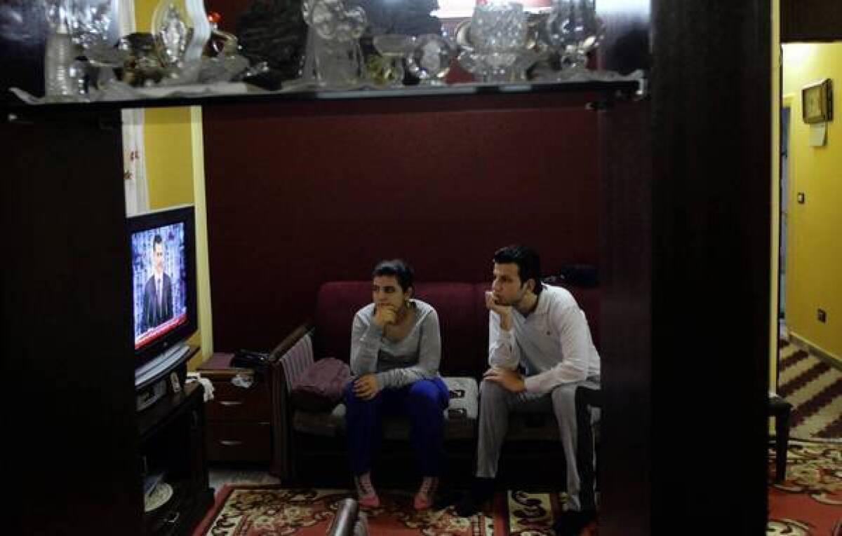 Viewers in Damascus watch Syrian President Bashar Assad speak about his own peace plan.