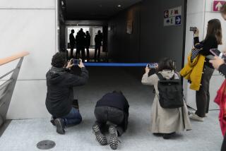 Varias personas toman fotos mientras oficiales de seguridad se reúnen en un corredor durante el registro de la oficina de Maximilian Krah, miembro del Parlamento Europeo, en el edificio de la institución en Bruselas, el 7 de mayo de 2024. (AP Foto/Virginia Mayo)