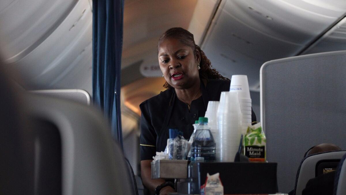 United Airlines flight attendant Charlotte Walters serves passengers on a flight from Houston to Chicago in May 2013.