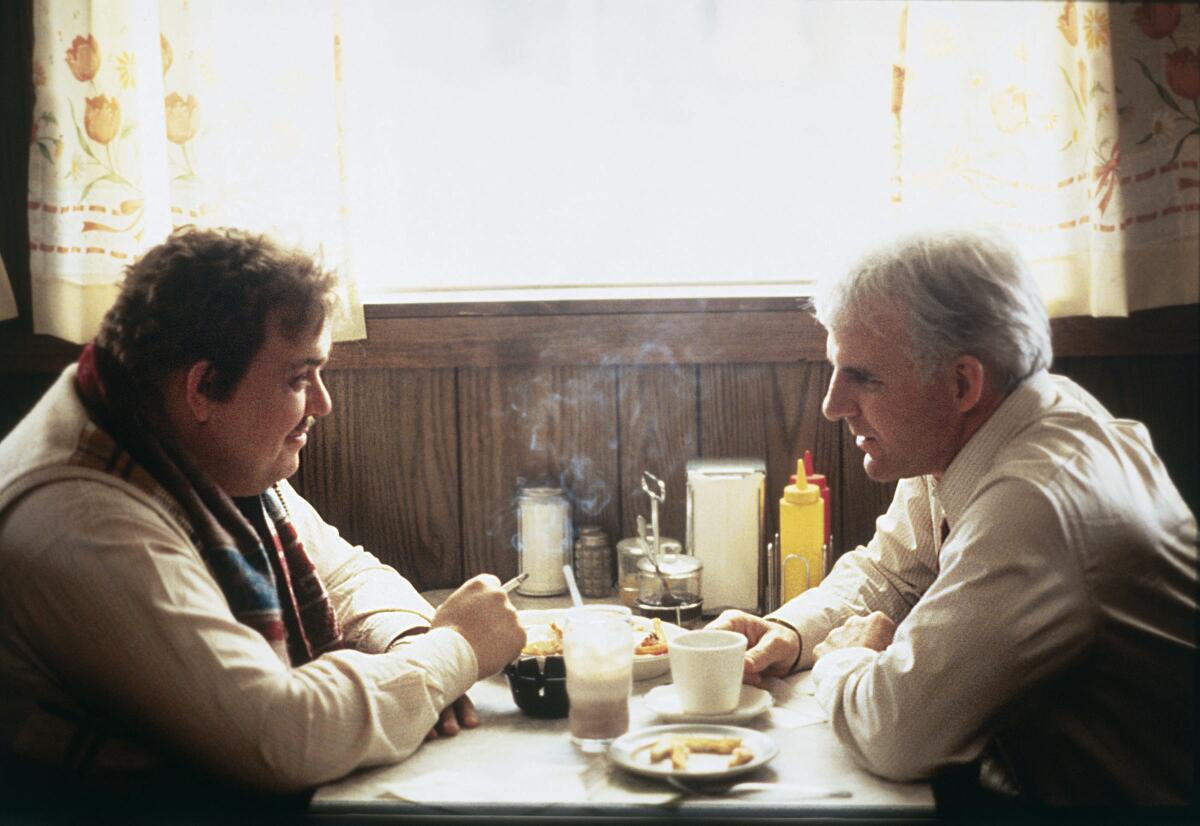 John Candy, left, and Steve Martin sit at a table in a diner.