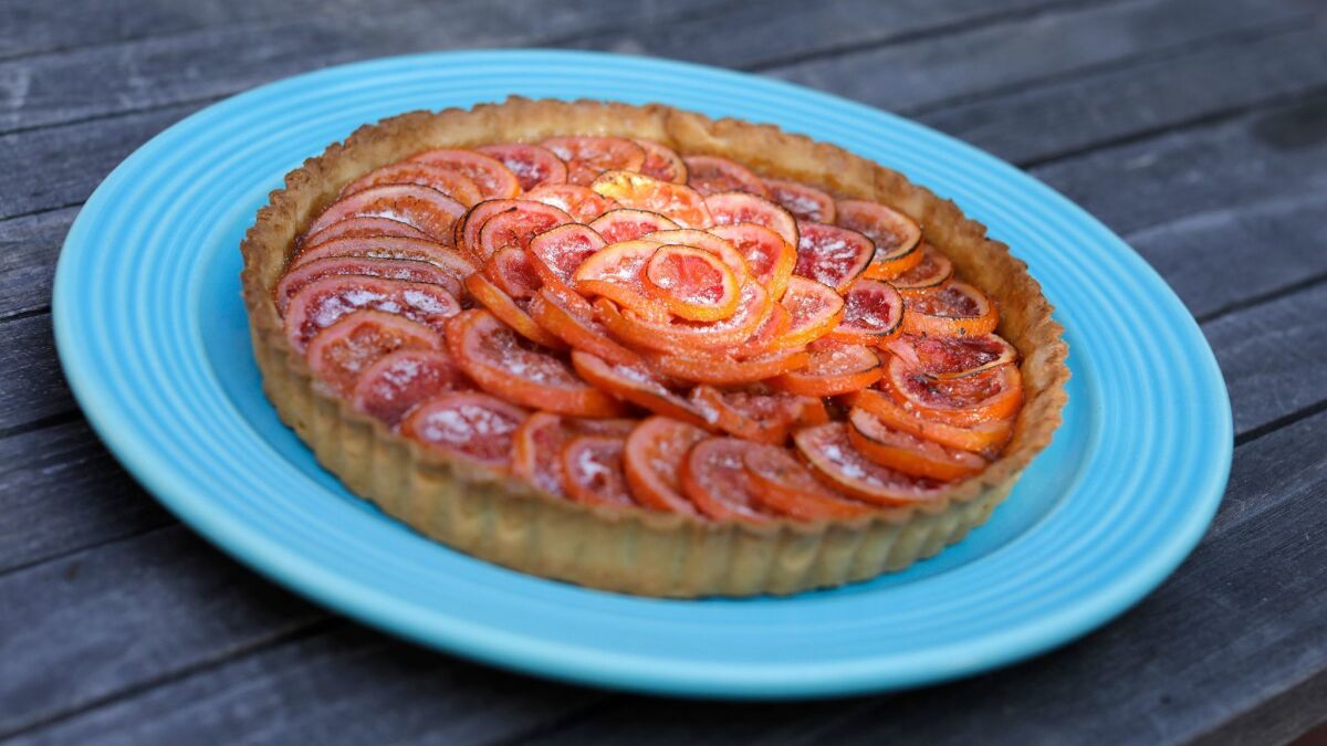 Blood orange compote is spread over the tart crust underneath a layer of poached sliced blood oranges in this Valencian orange and rhubarb tart.