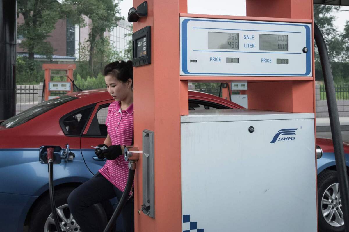 An attendant fills up a taxi with gasoline at a gas station in Pyongyang, North Korea, in 2017.